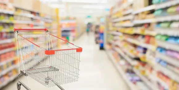 supermarket aisle blurred background with empty red shopping cart