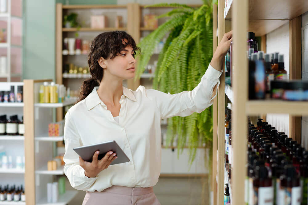 shop-assistant-with-tablet-standing-front-display