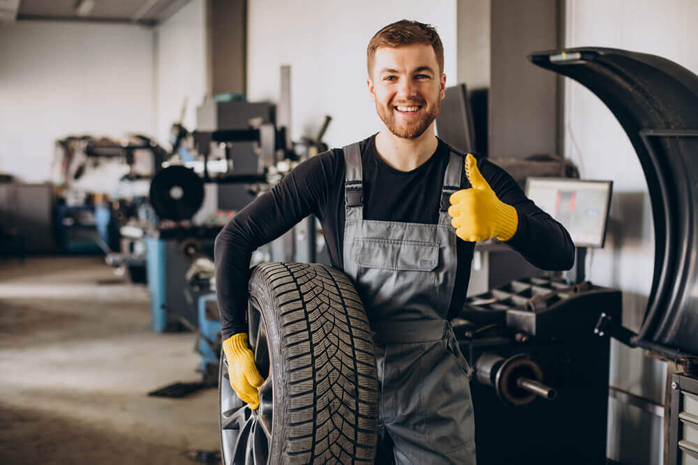 Car mechanic changing wheels