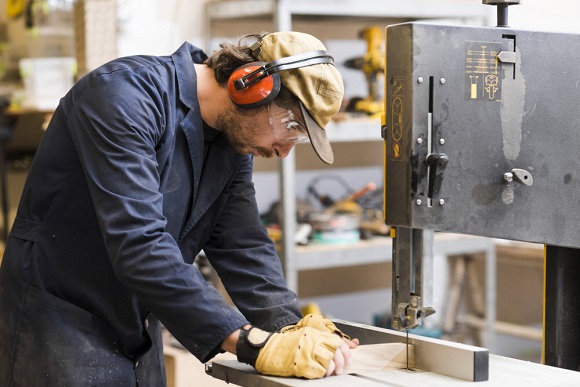 A manufacturing engineer carefully working on a machine